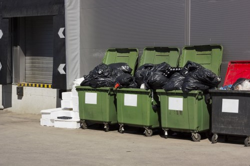 Staff wearing PPE performing secure loading of waste onto a vehicle